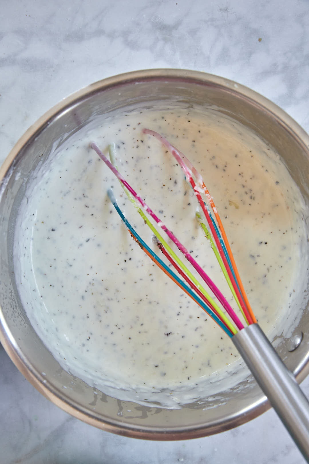 bechamel sauce with a whisk in it off the heat.