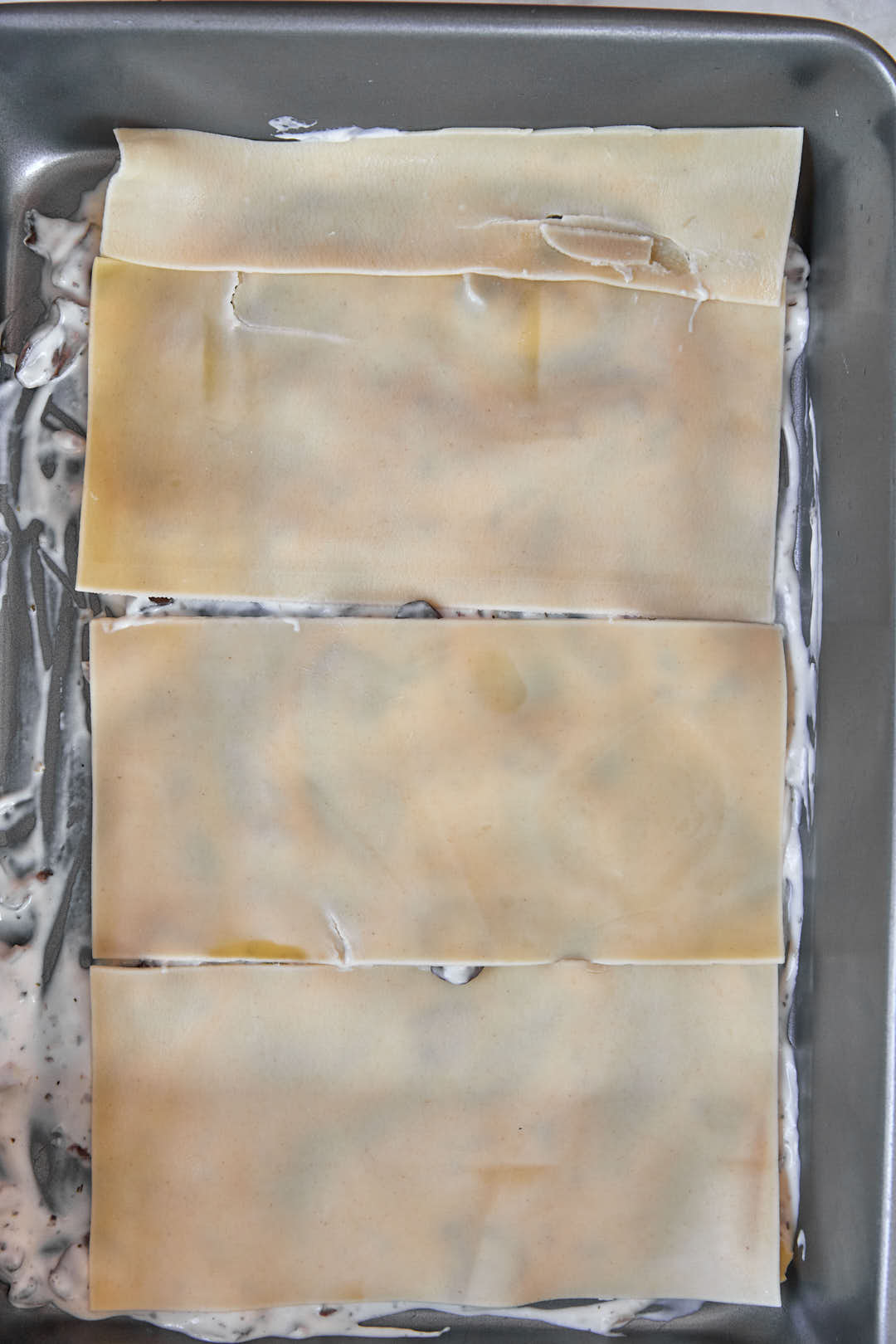 lasagna noodles layered onto bottom of a pan.