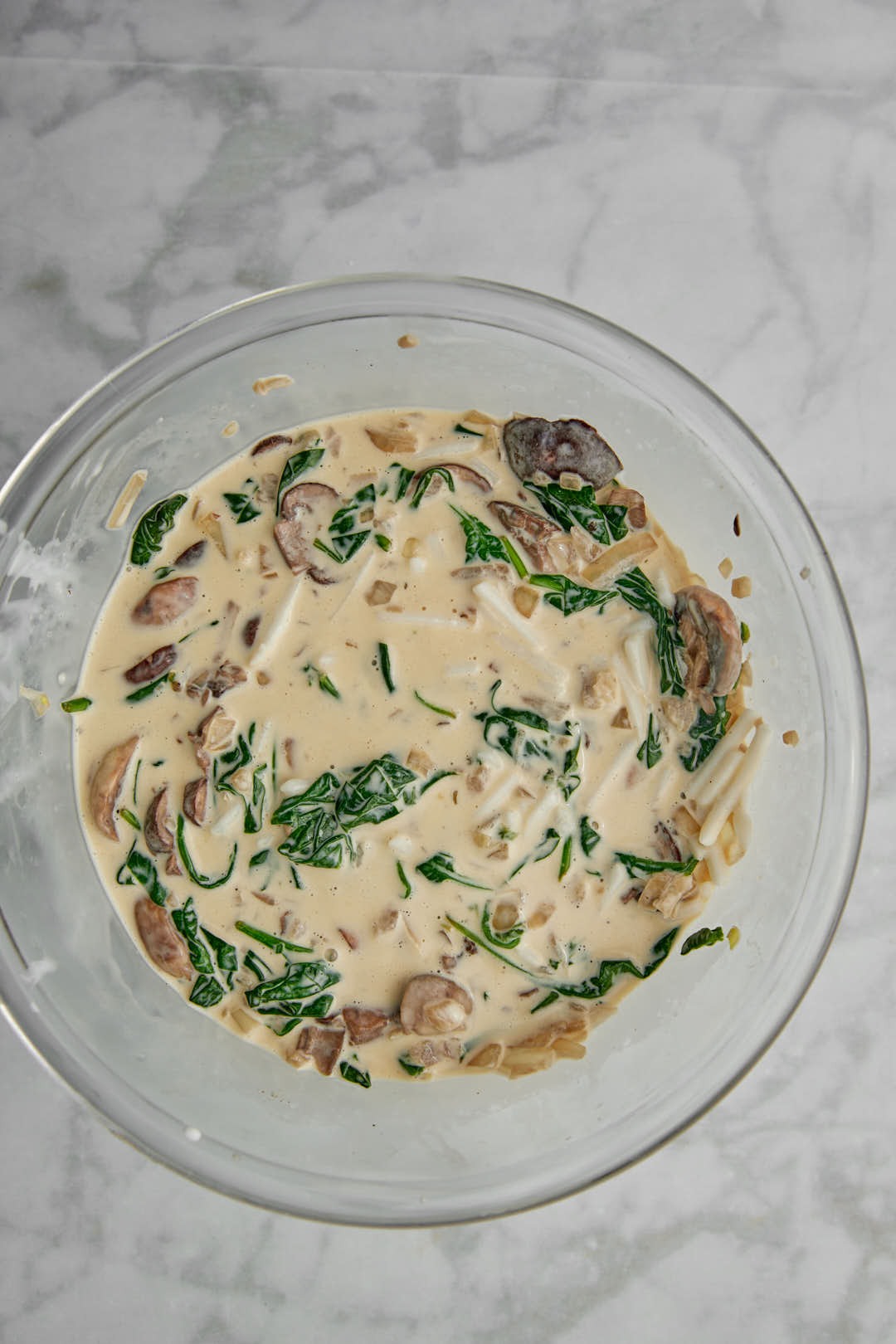 spinach and mushrooms added to whisked eggs and cream for quiche mixture.