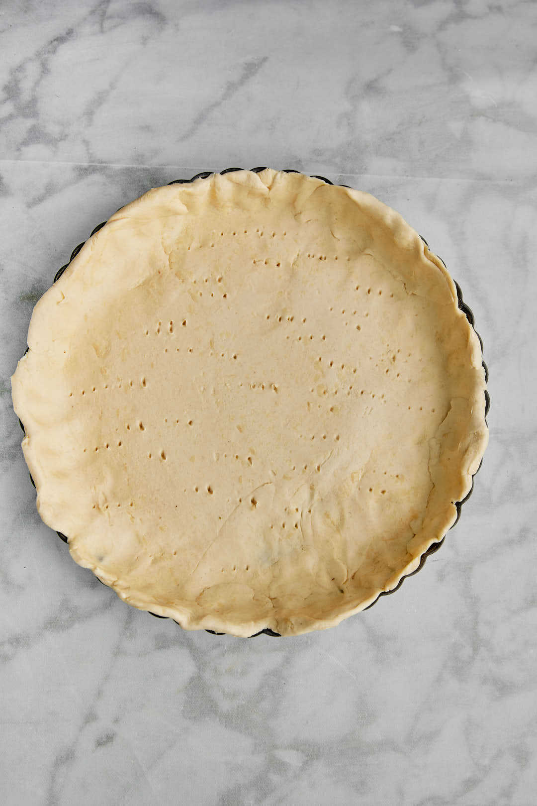 puff pastry crust for quiche in tart pan before baking.