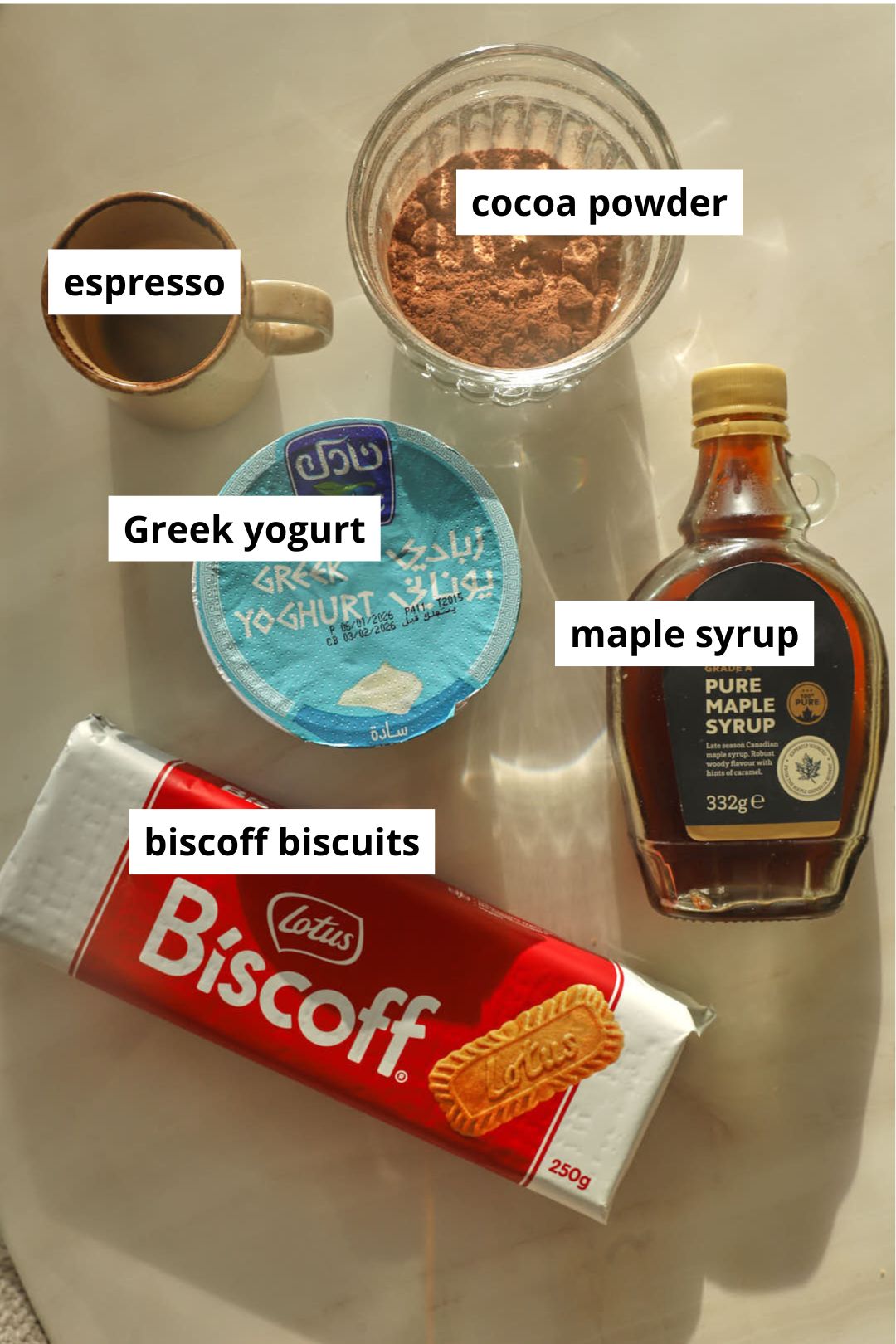 ingredients needed to make tiramisu greek yogurt on a white marble background.
