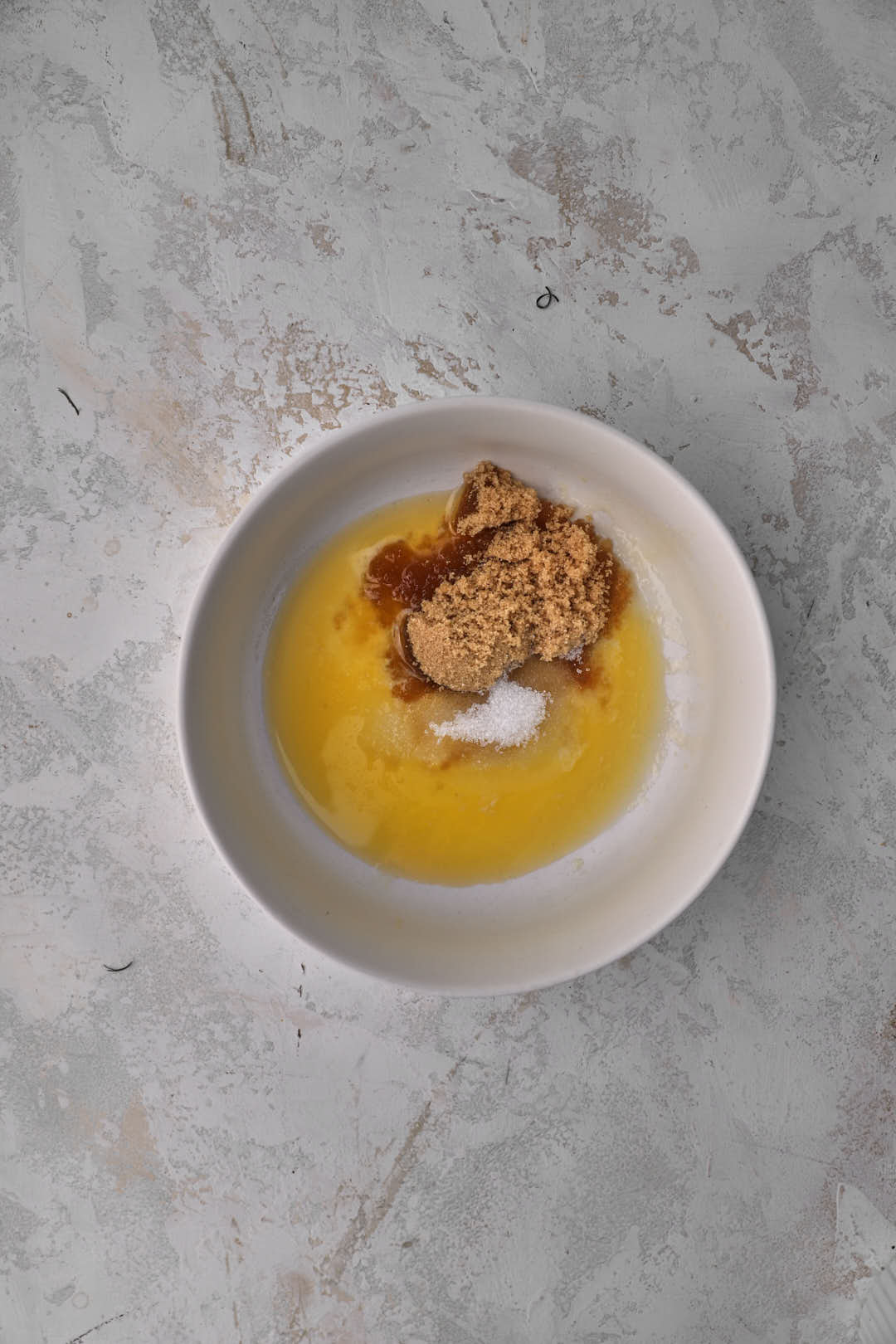 melted butter, brown sugar and sugar in a small white bowl.