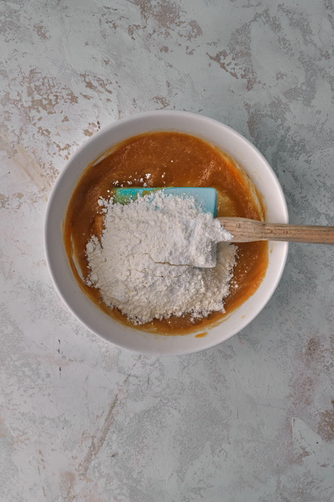 Flour added to brown sugar and butter mixture for cookie dough.