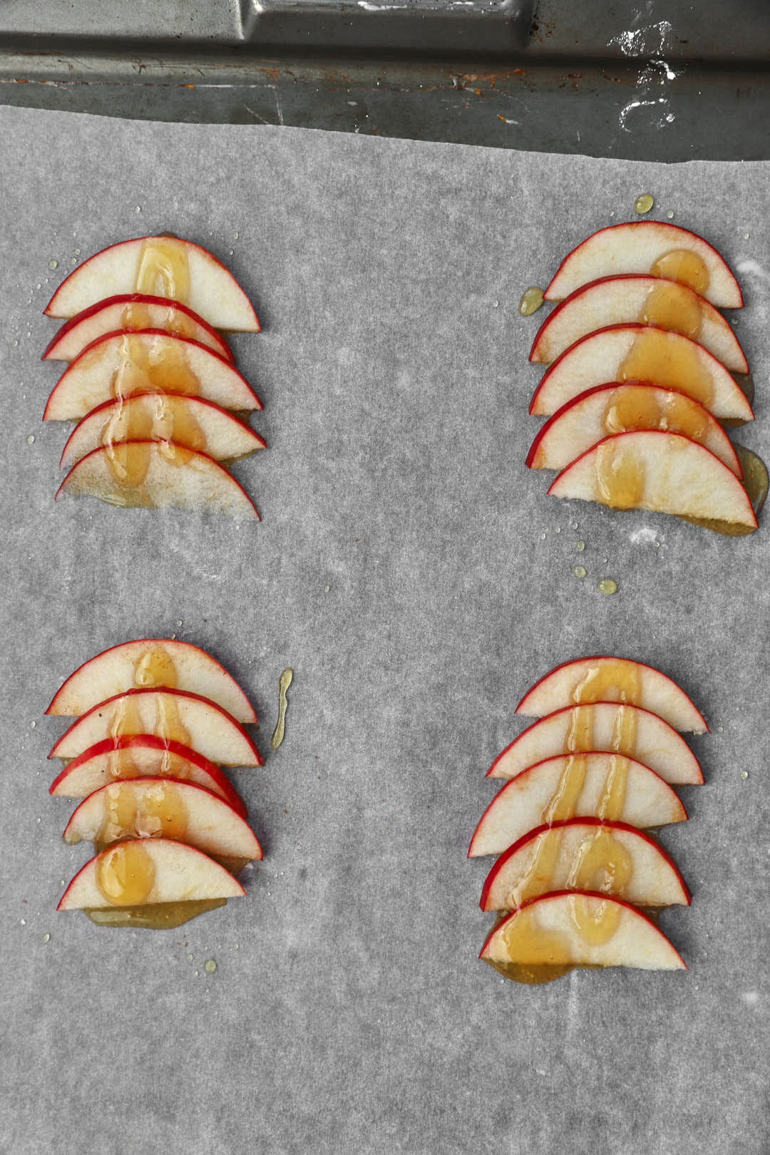 honey drizzled on apple slices on baking sheet.