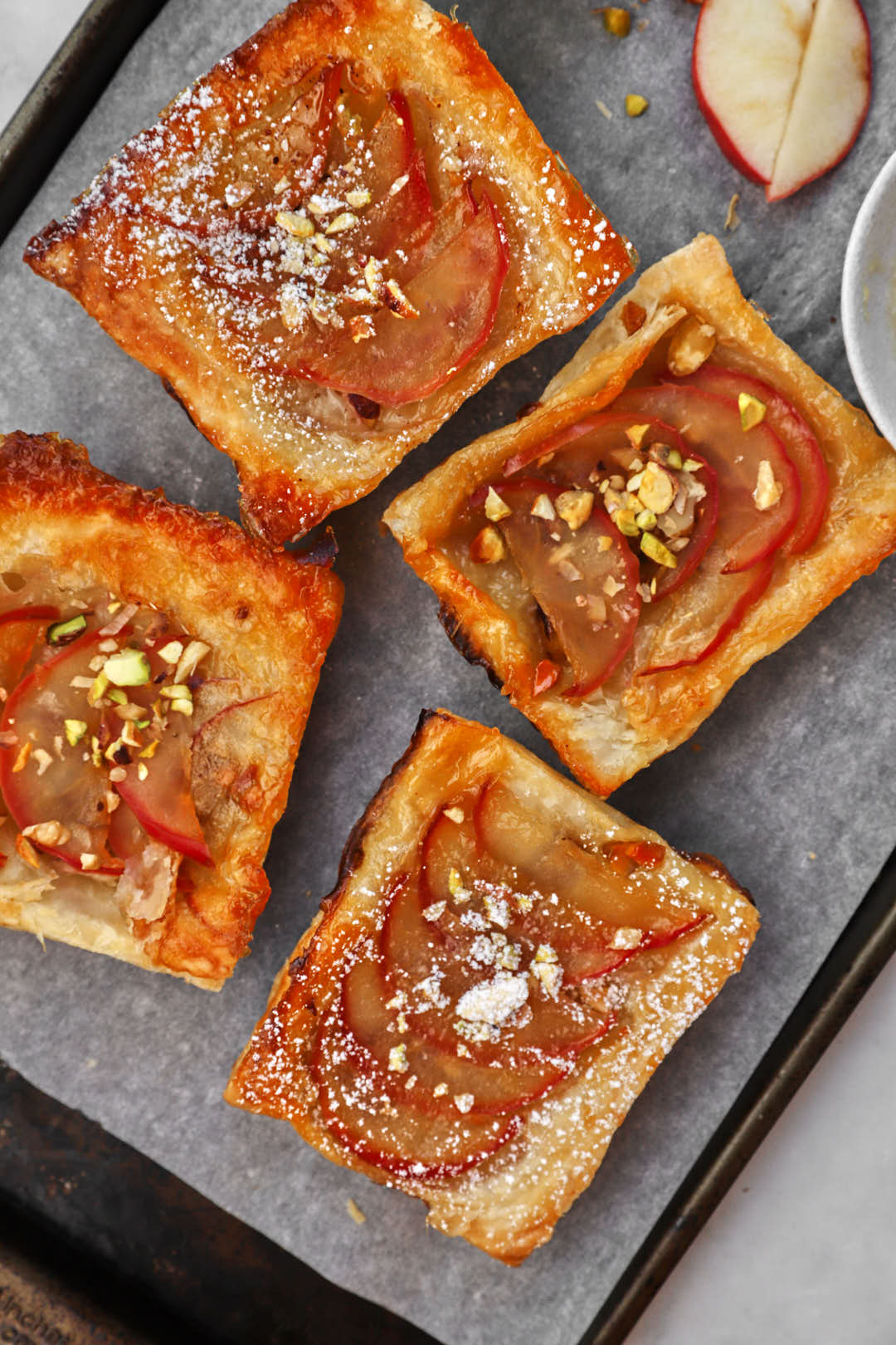apple puff pastry squares on parchment paper lined baking sheet.