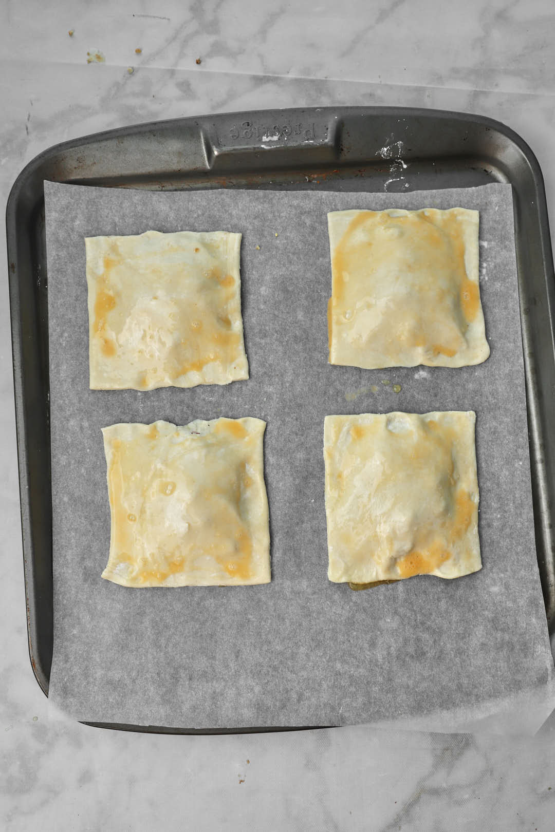 egg wash brushed puff pastry squares on baking sheet.