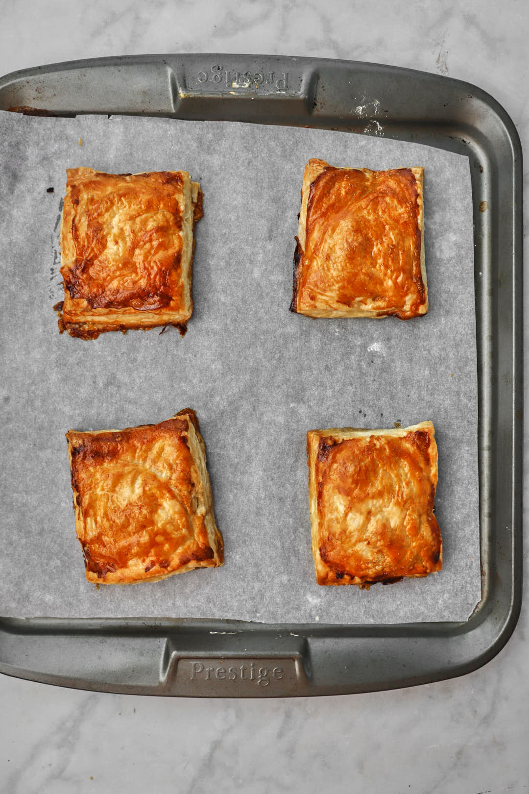 golden brown puff pastry squares after baking on baking sheet.
