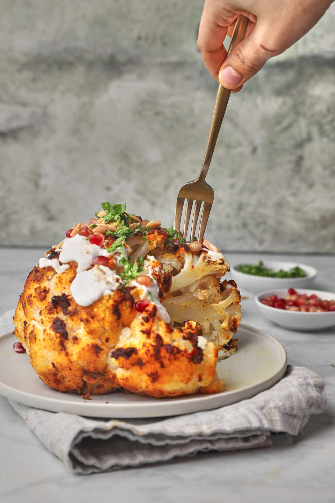 fork being poked into a whole roasted cauliflower.