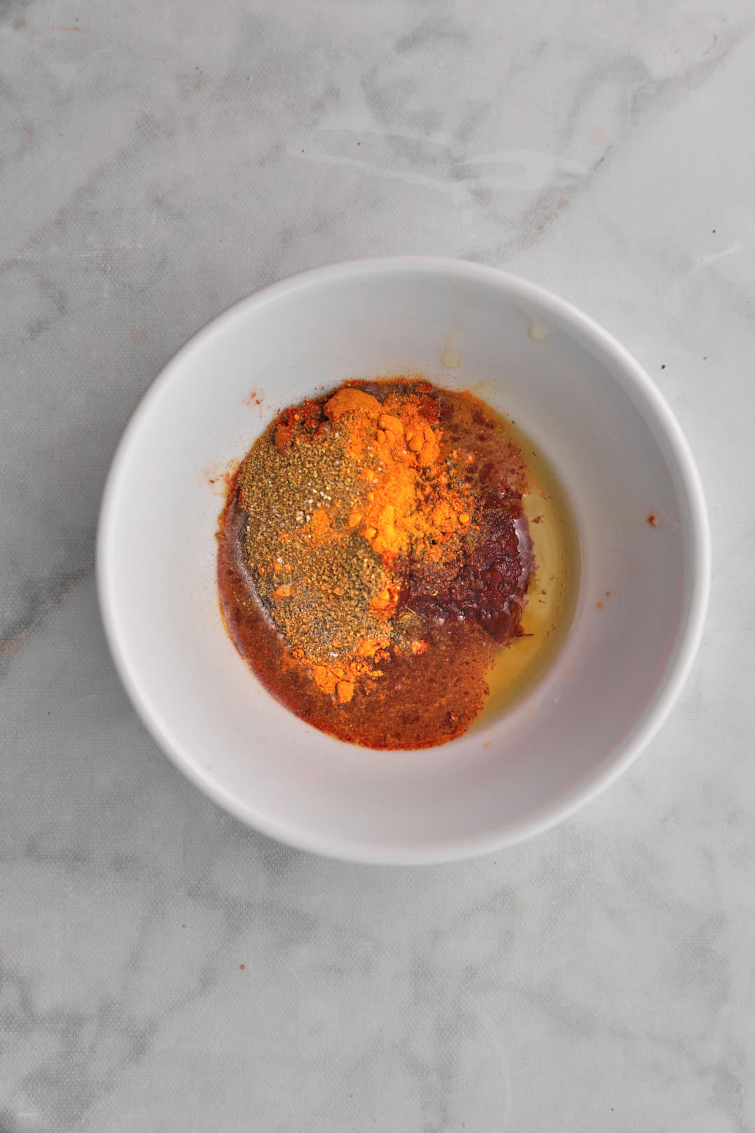 Ingredients for cauliflower spice rub in white bowl.